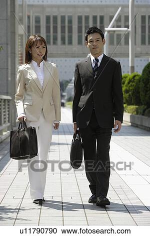 Stock Image - Front view of two professionals walking. Fotosearch