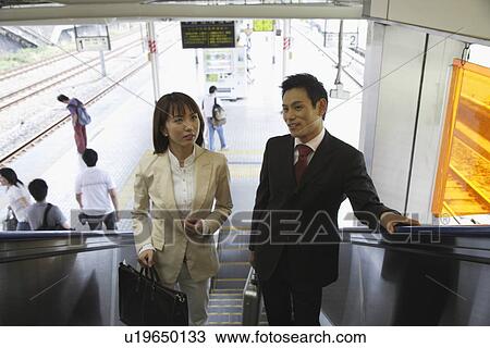 High angle view of two professionals on a escalator View Large Photo Image Stock Image - High angle view of two professionals on a escalator. Fotosearch