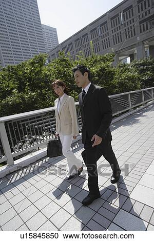 Stock Image - Side view of two professionals walking. Fotosearch