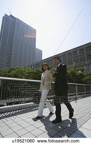 Stock Image - Side view of two professionals walking. Fotosearch