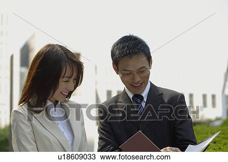 Stock Image - View of two professionals in a conversation. Fotosearch