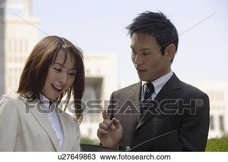 Stock Image - View of two professionals in a conversation. Fotosearch