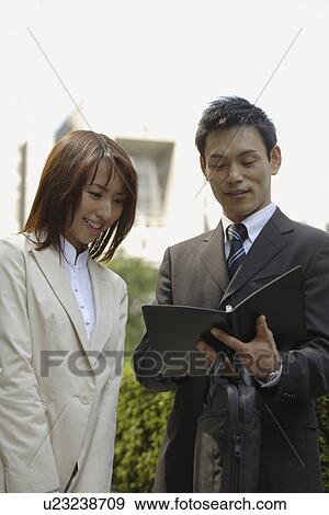 Stock Photo - View of two professionals in a conversation. Fotosearch
