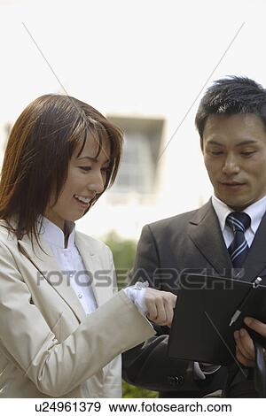 Stock Photo - View of two professionals in a conversation. Fotosearch