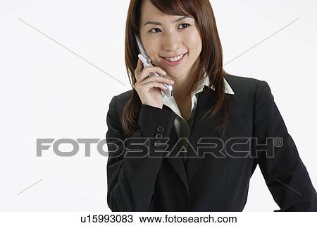 Stock Image - Businesswoman conversing on a cellphone, portrait. Fotosearch