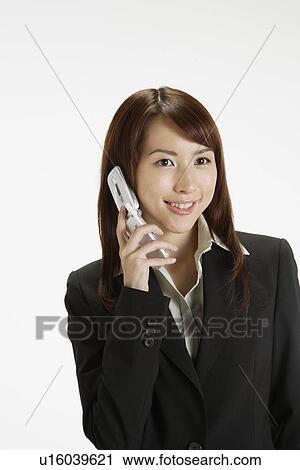 Stock Image - Businesswoman conversing on a cellphone, portrait. Fotosearch
