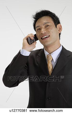 Stock Image - View of a professional talking on his mobile phone. Fotosearch