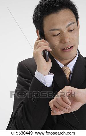 Stock Photo - View of a professional talking on his mobile phone. Fotosearch