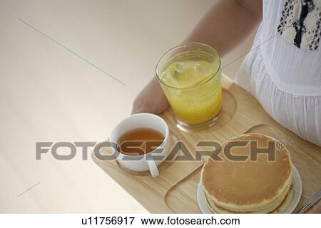 Stock Photo - A child holding a tray with some pancakes. Fotosearch