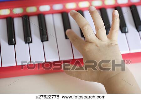 A child playing a toy organ View Large Photo Image Stock Photo - A child playing a toy organ. Fotosearch