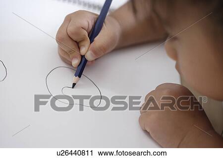 Stock Image - A girl drawing avidly. Fotosearch