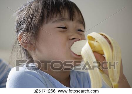 A girl eating banana View Large Photo Image Stock Photograph - A girl eating banana. Fotosearch