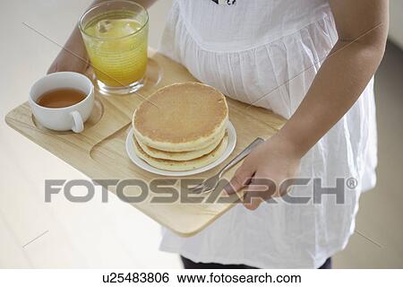 A girl holding a tray with some pancakes View Large Photo Image Stock Photograph - A girl holding a tray with some pancakes. Fotosearch