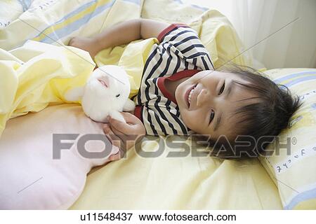 A girl in bed with a soft doll View Large Photo Image Stock Photo - A girl in bed with a soft doll. Fotosearch