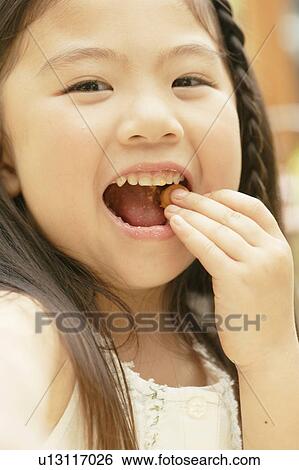 A portrait of a small girl eating chocolate View Large Photo Image Stock Photograph - A portrait of a small girl eating chocolate. Fotosearch