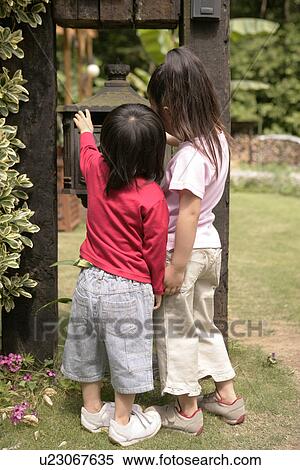 Rear view of two children looking at a metallic structure View Large Photo Image Stock Photography - Rear view of two children looking at a metallic structure. Fotosearch