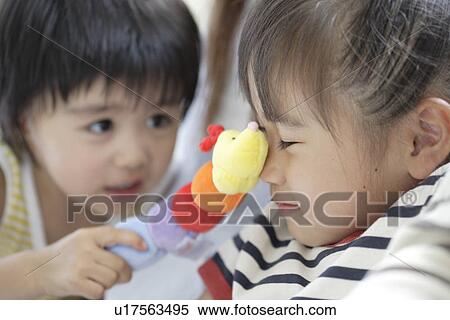 Stock Photography - Sister and brother playing with a soft doll. Fotosearch