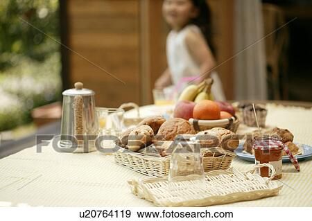 Some foodstuff kept on a table as a girl moves from the side View Large Photo Image Stock Photo - Some foodstuff kept on a table as a girl moves from the side. Fotosearch