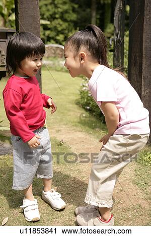 Stock Image - Two children enjoying themselves in the garden. Fotosearch