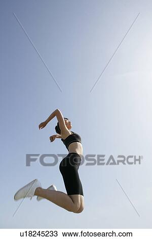 A low angle view of woman jumping in air View Large Photo Image Stock Image - A low angle view of woman jumping in air. Fotosearch