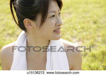 Stock Image - A side view of a woman with a towel around her neck. Fotosearch