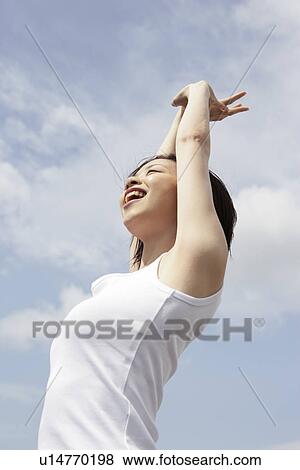 A woman stretching herself under the sky View Large Photo Image Stock Photo - A woman stretching herself under the sky. Fotosearch