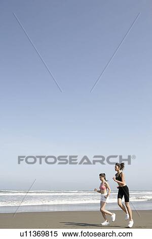 Stock Photography - Two women jogging on the seashore. Fotosearch