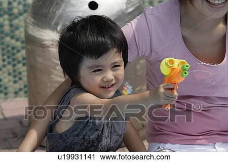 A boy playing with water pistol View Large Photo Image Stock Image - A boy playing with water pistol. Fotosearch