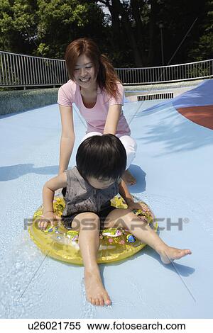 Stock Photography - A boy sliding down a water slide. Fotosearch