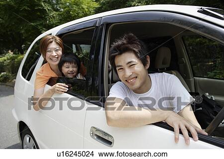Picture - A couple in a car with their son. Fotosearch