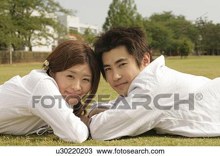 A couple lying in the garden faces the camera View Large Photo Image Stock Image - A couple lying in the garden faces the camera. Fotosearch