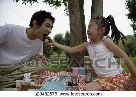 A daughter feeding a rice ball to her father View Large Photo Image Stock Photograph - A daughter feeding a rice ball to her father. Fotosearch