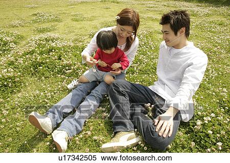 Stock Photography - A family relaxing in a garden full of flowers. Fotosearch