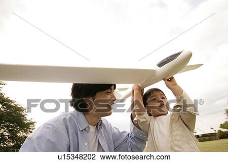 A father helping his son to hold an aeroplane View Large Photo Image Stock Image - A father helping his son to hold an aeroplane. Fotosearch