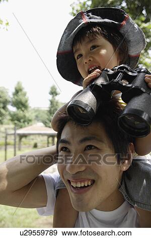 Stock Photo - A father holding his son on shoulders. Fotosearch