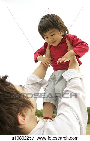 A father lifting his son in air View Large Photo Image Stock Photo - A father lifting his son in air. Fotosearch