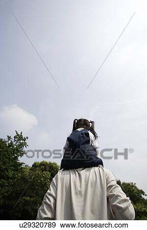 A girl riding her father's shoulders View Large Photo Image Stock Photo - A girl riding her father's shoulders. Fotosearch