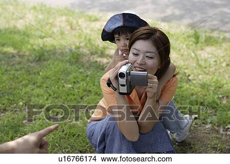 Picture - A mother shooting video. Fotosearch