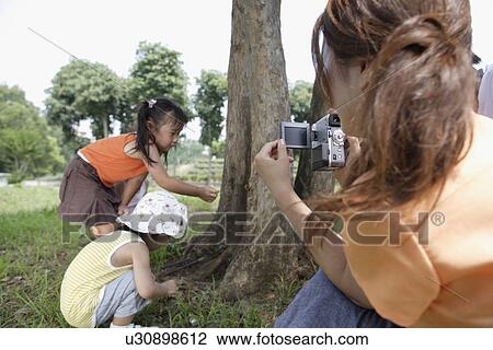 Stock Image - A mother shooting video. Fotosearch