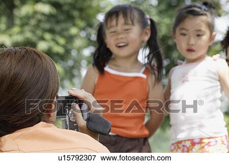 Stock Photo - A mother shooting video. Fotosearch
