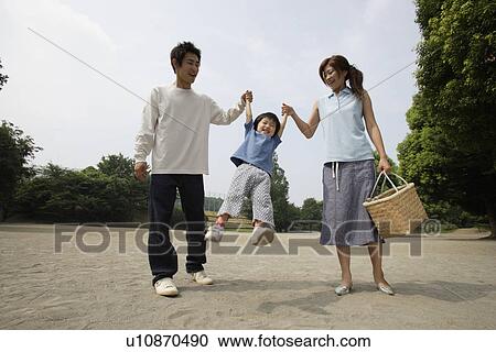 Stock Image - A young couple with a boy in park. Fotosearch