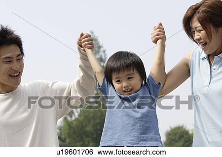 Stock Photograph - A young couple with a boy in park. Fotosearch