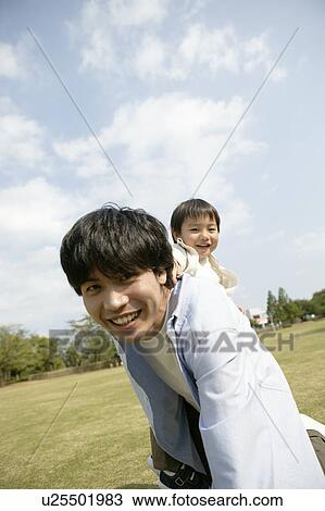 Son enjoying himself as he sits on his fathers back View Large Photo Image Stock Image - Son enjoying himself as he sits on his fathers back. Fotosearch