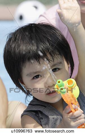 A boy holding a water pistol View Large Photo Image Stock Image - A boy holding a water pistol. Fotosearch