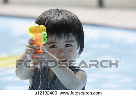 Stock Image - A boy holding a water pistol. Fotosearch