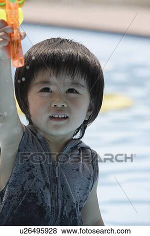 A boy holding a water pistol View Large Photo Image Stock Photo - A boy holding a water pistol. Fotosearch