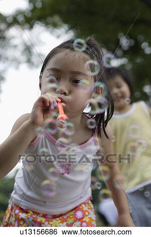 A girl blowing bubbles View Large Photo Image Stock Photograph - A girl blowing bubbles. Fotosearch