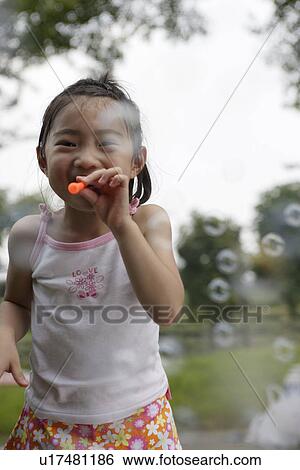 A girl blowing bubbles View Large Photo Image Stock Photograph - A girl blowing bubbles. Fotosearch