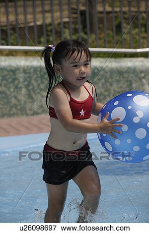 Stock Photo - A girl in a pool with beach ball. Fotosearch