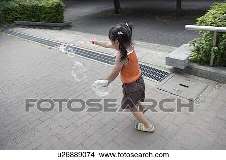 Picture - A girl playing bubbles. Fotosearch